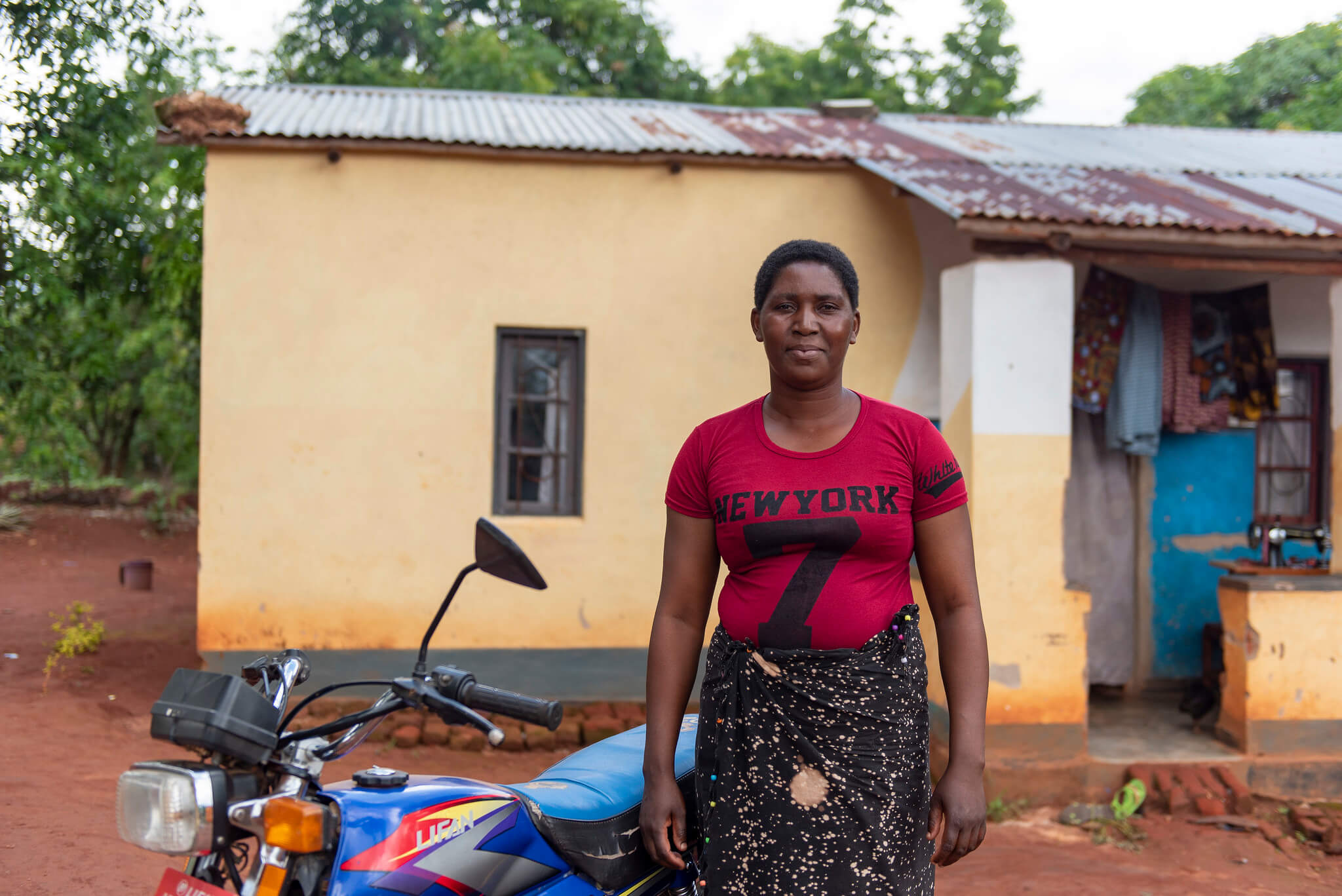 Portrait of Fanny Paul with the motorcycle she was able to buy through her local VSLA, set up through the Kuwala initiative. Mukuta village, Mulanje District, Malawi. Image: ETP