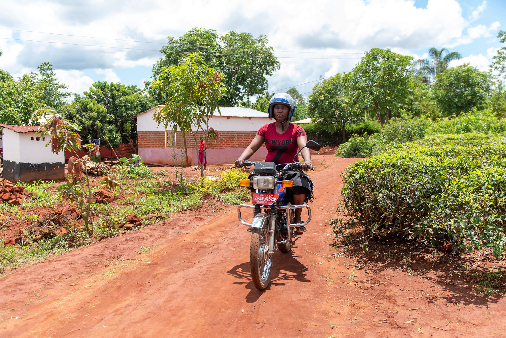 Fanny Paul rides the motorcycle she was able to buy through her local VSLA, set up through the Kuwala initiative. Mukuta village, Mulanje District, Malawi. Image: ETP